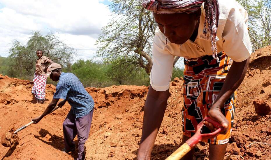 Wenig Unterstützung für die Ärmsten der Armen Männer und Frauen graben auf einem Feld.