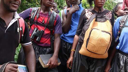 Fünf Menschen stehen im Wald.
