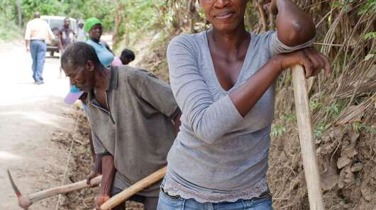 Haiti nach dem Erdbeben. Bild: Eine Frau mit einem Spaten.
