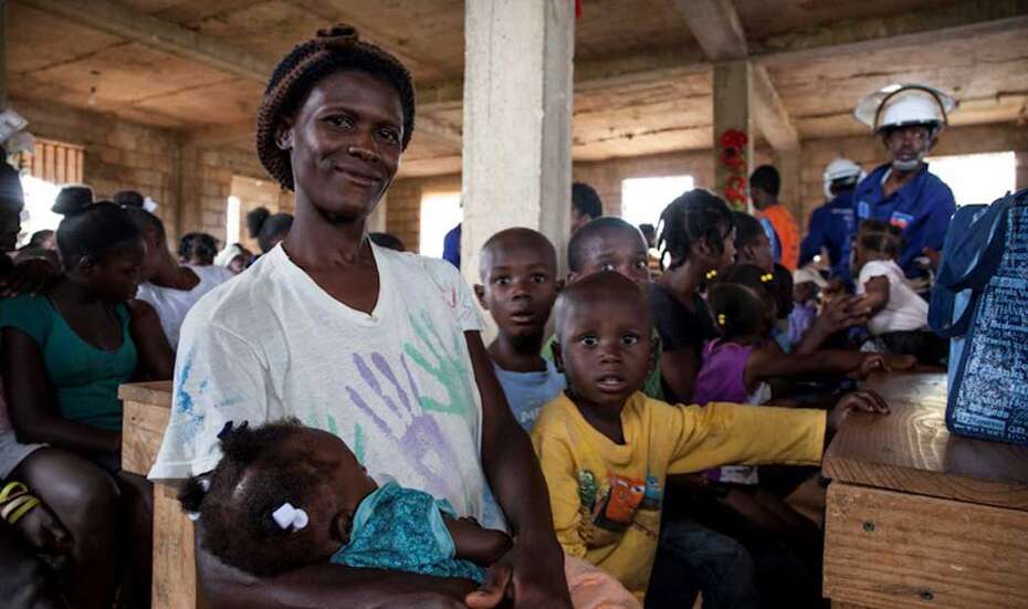 Eine Mutter wartet mit ihren Kindern auf Essen.