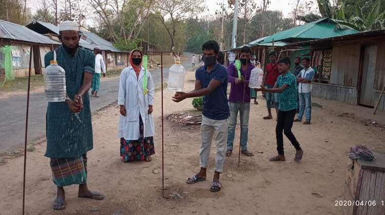 2020-haende-waschen-corona-bangladesh-welthungerhilfe.jpg Verschiedene Menschen waschen sich an Hygienestationen die Hände.