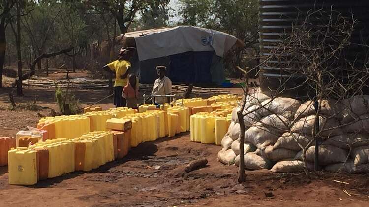 Umfüllung für den Eigenbedarf Flüchtlinge zapfen sich Wasser aus den Tanks in Kanister.