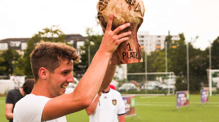 Glückliches Strahlen: Einer der Spieler aus dem Gewinnerteam hält den Pokal vom ersten #ZeroHunger-FootballCup 2018 in die Höhe.