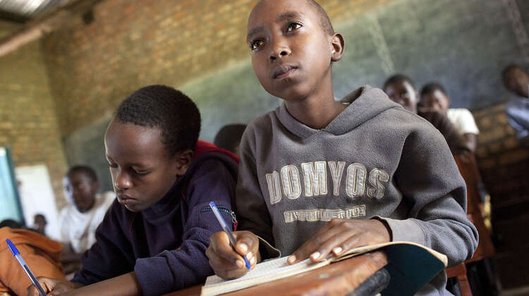 Zwei Schüler machen im Unterricht Notizen.