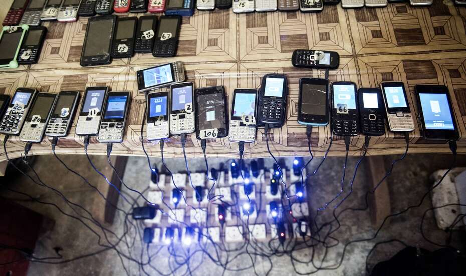 Viele Handys laden an einer Aufladestation, Sierra Leone.