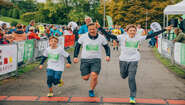 Zwei Kinder und ein Erwachsener laufen beim ZeroHungerRun ins Ziel