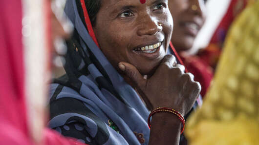 Eine lächelnde Frau in Nahaufnahme, um sie heraum sind weitere Frauen zu sehen.