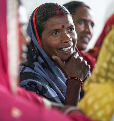 Eine lächelnde Frau in Nahaufnahme, um sie heraum sind weitere Frauen zu sehen.