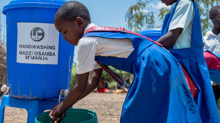 Ein Mädchen wäscht ihre Hände.