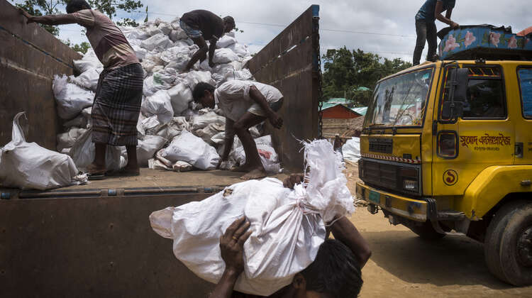 Im Camp Hakimpara in Bangladesch: Die lokale Hilfsorganisation FIVDB verteilt Säcke mit Holzkohle und Reisschalenbriketts an geflüchtete Rohingya (August 2018).