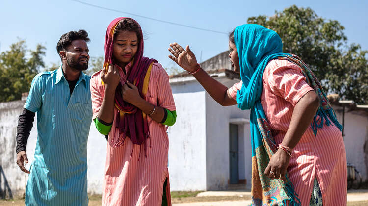 Zwei Frauen und ein Mann spielen in einem Theaterstück.