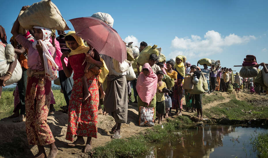 Flüchtlinge der Rohingya aus Myanmar überqueren die Grenze nach Bangladesch. Ihr Hab und Gut tragen sie dabei auf ihren Schultern.