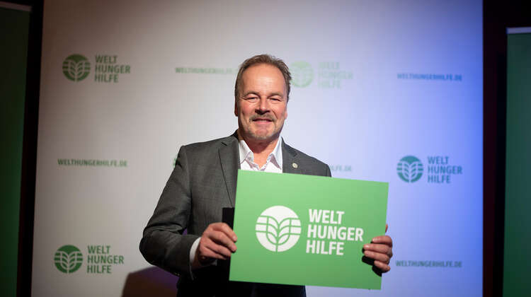 Till Demmtrøder hält Schild der Welthungerhilfe in die Kamera