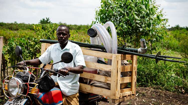 Ein Bauer in Uganda auf einem Moped, 2021.