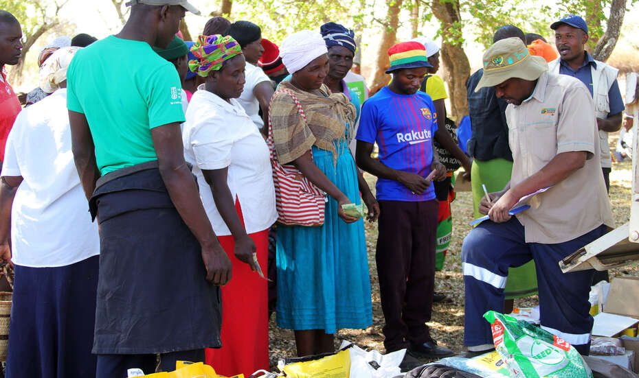 Mehrere Männer und Frauen bei der Ausgabe hochwertiger Saatgüter