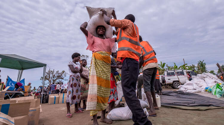 2019-zyklon-idai-hilfsgueterverteilung-nhamatanda-mosambik-tommy-tenchard-concern-2.jpg Eine Frau erhält Pakete und Säcke voller Hilfsgüter.