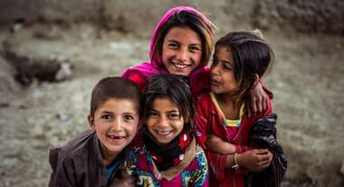 Eine Gruppe Kinder in bunter Kleidung nimmt an einem Kinderzirkus teil