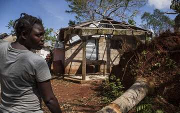 Mann steht vor zerstörtem Haus
