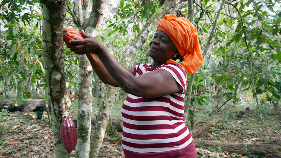 Eine Bäuerin hält etwas von ihrem Ertrag in der Hand
