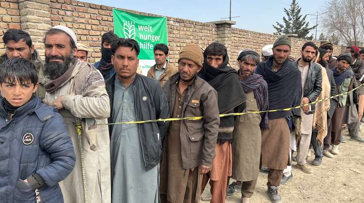 Männer stehen bei einer Lebensmittelverteilung in Kabul, Afghanistan, Schlange.