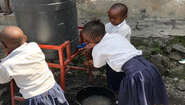 Ebola-Prävention in der Demokratischen Republik Kongo: Schulkinder waschen sich an einem kleinen Wassertank die Hände. Schulkinder waschen sich an einem kleinen Wassertank die Hände.
