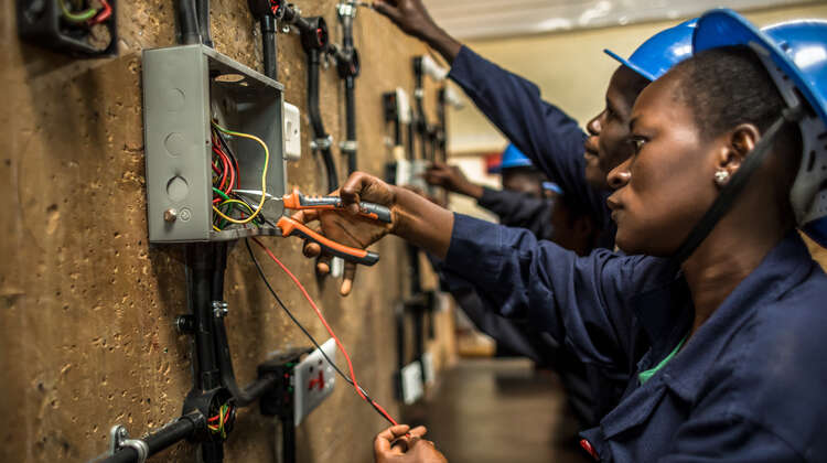 2018-pressefoto-auszubildende-handwerker-skill-up-kenia_C_natalia-jidova.jpg Eine Auszubildende steht an der Wand und arbeitet.