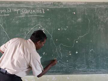 Ein Lehrer schreibt etwas an die Tafel