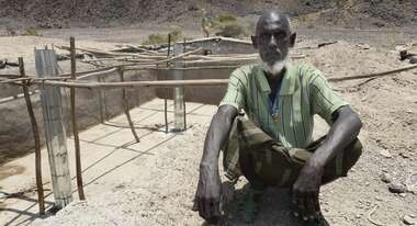 Yusuf sitzt auf dem ausgetrockneten Boden in seinem Dorf Afar © Jens Grossmann