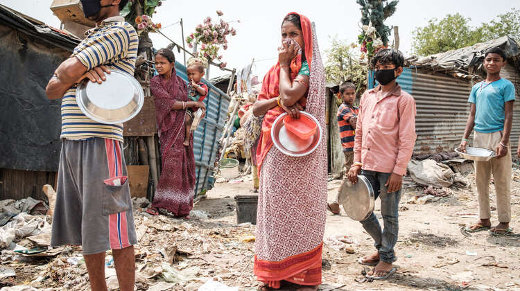Ein Mann, eine Frau und zwei Jungen mit Masken warten in einer Schlange.