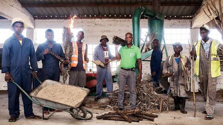 Eine Gruppe Männer in Arbeitskleidung in einem Recyclinghof.