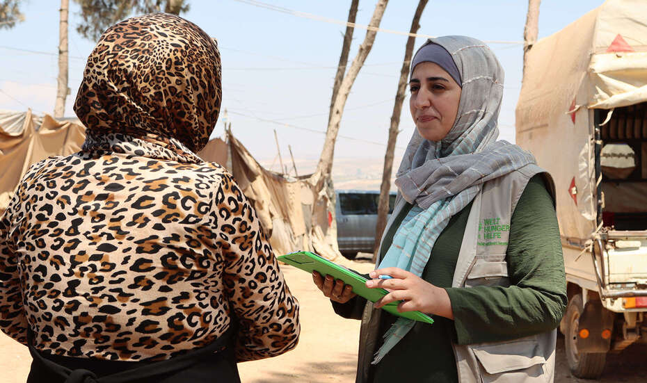 Welthungerhilfe-Mitarbeiterin im Gespräch mit einer Frau in einem Flüchtlingslager in Syrien