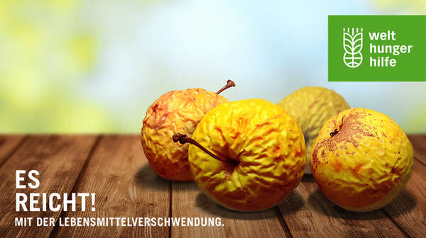 "Es reicht! Mit der Lebensmittelverschwendung": verdorrte Äpfel auf dem Kampagnen-Banner