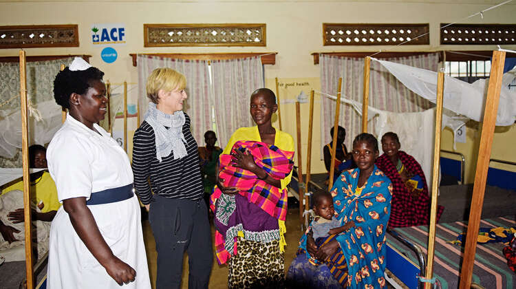 Schauspielerin Gesine Cukrowski, eine Krankenschwester und mehrere Frauen. Im Hintergrund sieht man Betten.