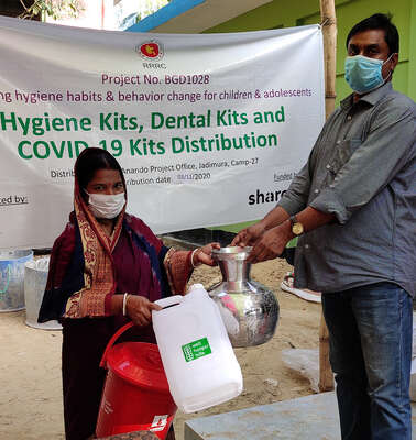 Eine Frau bekommt ein Hygiene-Paket für den Schutz gegen Corona, Bangaldesch 2021.