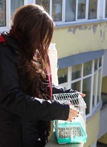 Ein Mädchen mit Vogelkäfig.