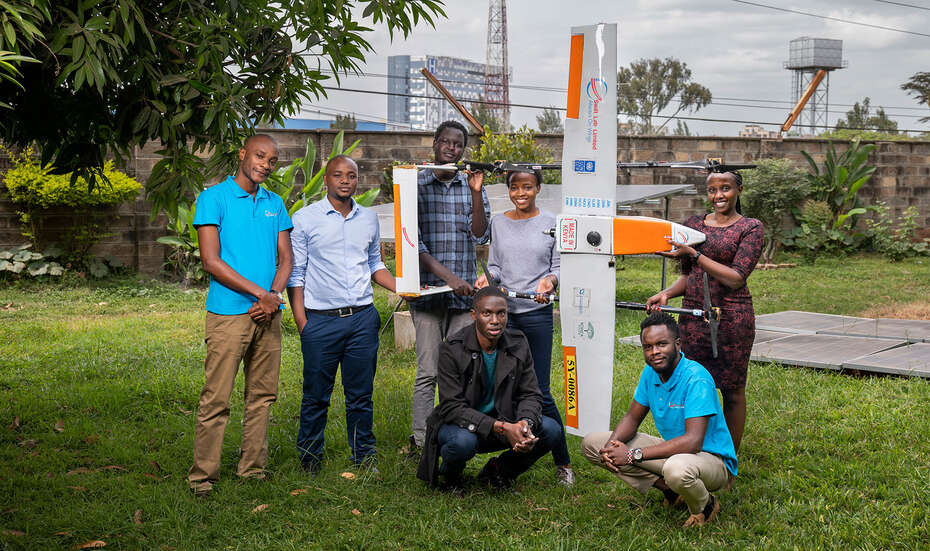 Team von Swift Lab: Sieben junge Leute lächeln in die Kamera und halten ein Flugobjekt mit Drohne.