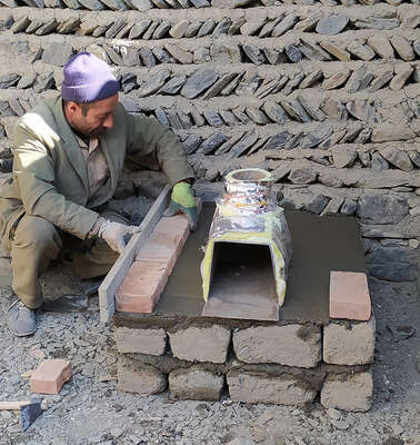 Ein Mann baut einen energieeffizienteren Ofen, Tadschikistan 2021.
