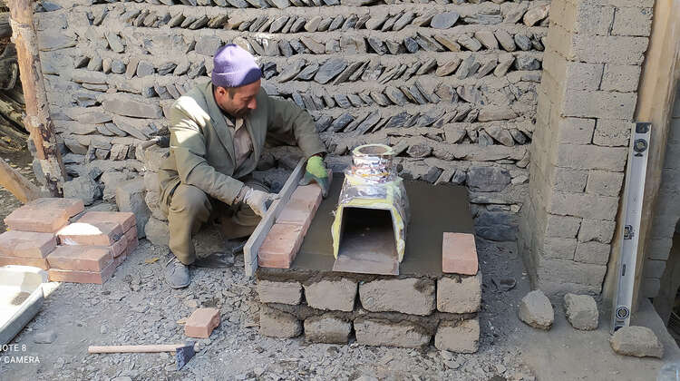 Ein Mann baut einen energieeffizienteren Ofen, Tadschikistan 2021.