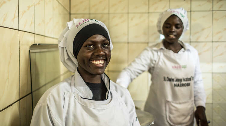 2018-pressefoto-auszubildende-skill-up-kenia_C_natalia-jidovanu.jpg Eine junge Frau mit einer Koch-Haube lächelt in die Kamera.