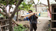 2019-nothilfe-tsunami-ueberlebender-indonesien_C_acted.jpg Ein Mann trägt zwei Holzlatten auf seiner Schulter.