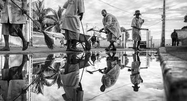 Vier Straßenfeger putzen die Straße 