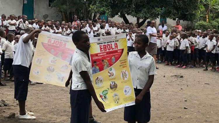 Schulkinder in der Nähe von Goma (D. R. Kongo) halten Informations-Plakate über die Gefahren, Ansteckungswege und Symptome von Ebola sowie über Präventionsmaßnahmen. Schulkinder in der Nähe von Goma (D. R. Kongo) halten Informations-Plakate über die Gefahren, Ansteckungswege und Symptome von Ebola sowie über Präventionsmaßnahmen.