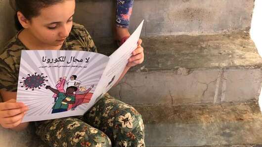 Ein Mädchen liest einen Comic auf der Treppe, Türkei 2020. 