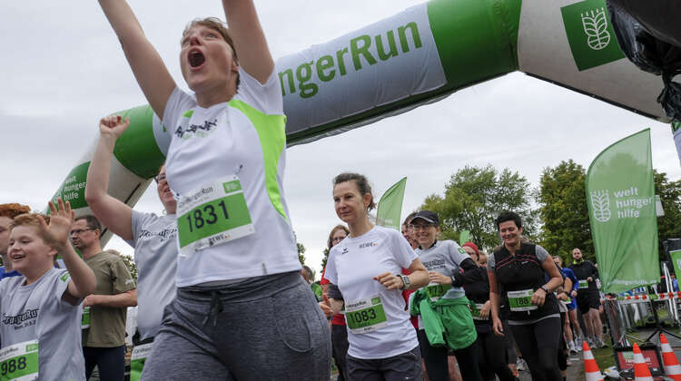 Eine Frau jubelt an der Ziellinie.