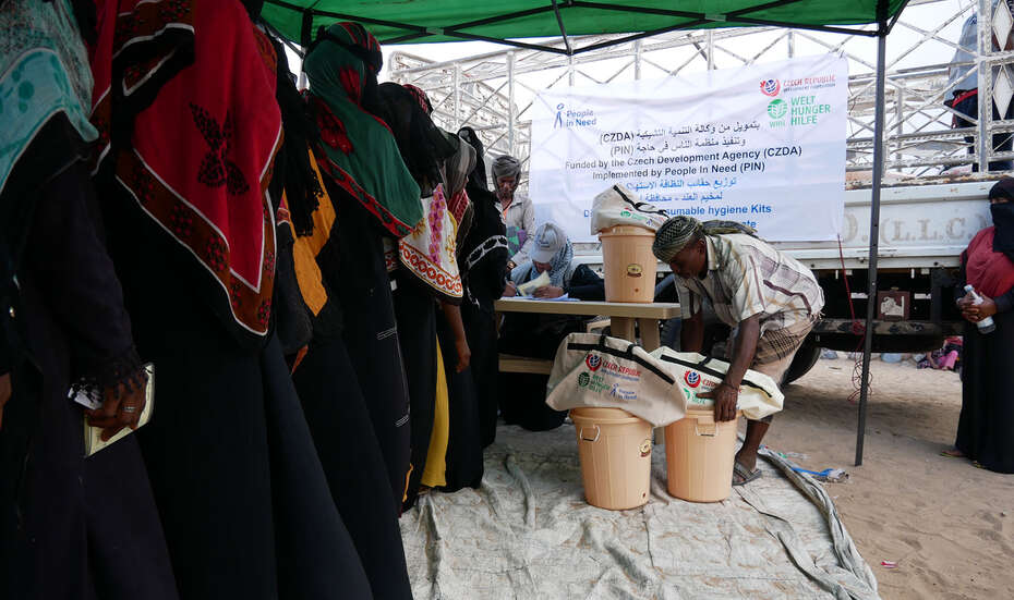 Menschen im Jemen stehen Schlange bei der Verteilung von Hygienekits in Eimern