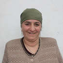 Eine Frau vor einer weißen Häuserwand, Tadschikistan 2021.