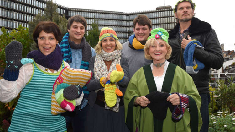 Mehrere Prominente und myBoshi Mitarbeiter posieren mit ihren fertig gehäkelten Produkten.