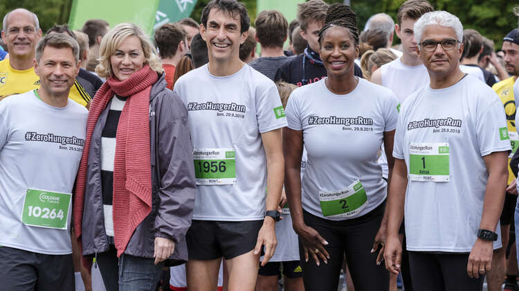 Fünf Menschen schauen lachend in die Kamera.