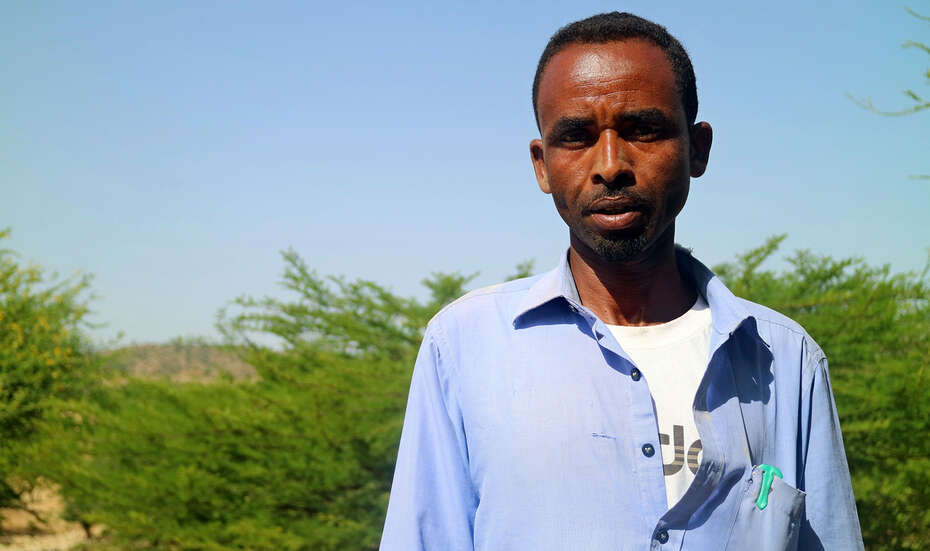 Ein Kleinbauer mit blauem Hemd schaut in die Kamera.