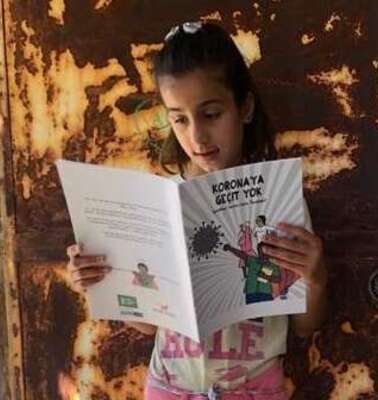 Ein Mädchen liest in einem Heft.